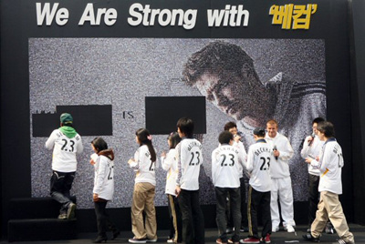 데이비드 베컴이 29일 서울 청계광장에서 열린 아디다스의 'We Are Strong with 베컴'행사에서 자신의 대형 포토월을 만들고 있는 팬들과 악수를 하고 있다. 
