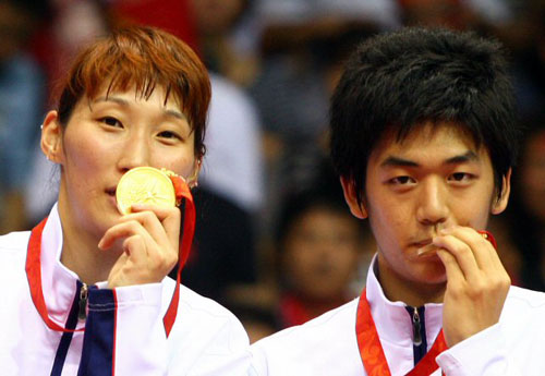 17일 베이징공과대학 체육관에서 열린 올림픽 배드민턴 혼합복식 결승 한국-인도네시아 전에서 2-0완승을 거두며 우승한 이효정과 이용대가 시상식을 마친 뒤 금메달에 키스하고 있다. 