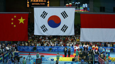 17일 베이징공과대학 체육관에서 열린 배드민턴 혼합복식 결승 이용대(20)-이효정(27) 선수가 인도네시아의 위디안토-릴리아나와의 경기에서 금메달을 딴 뒤 시상식에서 태극기가 게양되는 것을 바라보고 있다. 