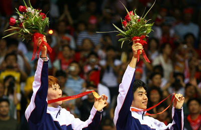 17일 베이징공과대학 체육관에서 열린 올림픽 배드민턴 혼합복식 결승 한국-인도네시아 전에서 2-0완승을 거두며 우승한 이효정과 이용대가 시상대에서 금메달을 들어보이며 관중들에게 인사하고 있다. 