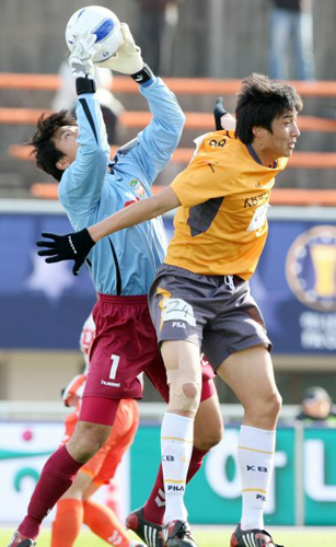  18일 제주종합운동장에서 열린 2008 하나은행 FA컵 전국축구선수권대회 4강전에서 경남FC의 골키퍼 이광석이 고양 국민은행의 조세권과 함께 점프해 공중볼을 잡아내고 있다. 