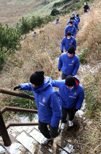 축구 국가대표팀이 12일 오전 제주도 서귀포시 성산일출봉 정상에 올라 분화구를 횡단한 뒤 계단을 오르고 있다.
 