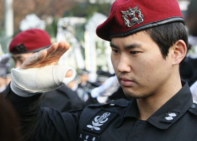  22일 오전 송파구 경찰병원에서 열린 고(故) 김남훈(31) 경사 영결식에서 팔에 부상을 입은 한 특공대원이 고인을 향해 경례하고 있다. 고(故) 김남훈(31) 경사는 지난 20일 용산 철거민 진압작전을 벌이던 도중 순직했다. 