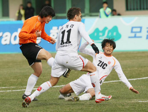 8일 강릉종합운동장에서 열린 2009 프로축구 K리그 신생팀 강원FC-제주 유나이티드 경기에서  강원 윤준하(왼쪽)가 상대 수비를 피해 첫 골을 떠뜨리고 있다. 