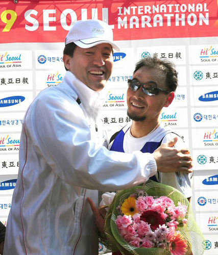 15일 서울 시내 일원에서 열린 2009 서울국제마라톤대회에서 완주한 이봉주(오른쪽)가 오세훈 서울시장으로부터 꽃다발을 받고 있다. 