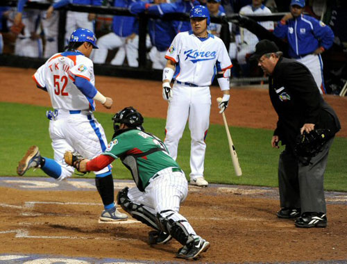 16일(한국시간) 미국 샌디에이고 펫코파크에서 열린 2009 월드베이스볼클래식(WBC) 2라운드 대한민국-멕시코 경기에서 한국 3루 주자 김태균(왼쪽)이 7회말 이용규의 희생 플라이 때 멕시코 포수 로드 바라하스의 태그를 피해 득점에 성공하고 있다. 