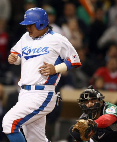 16일(한국시간) 미국 샌디에이고 펫코파크에서 열린 2009 월드베이스볼클래식(WBC) 2라운드 대한민국-멕시코 경기에서 한국 3루 주자 김태균(왼쪽)이  7회말 이용규의 희생플라이 때 홈을 밟고 있다. 