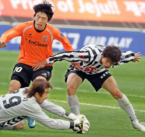 5일 오후 제주월드컵경기장에서 열린 프로추구 제주유나이티드와 경남FC의 경기에서 경남 김태욱이 제주 구경현을 막는 사이 김병지 골키퍼가 공을 잡아내고 있다. 
 
