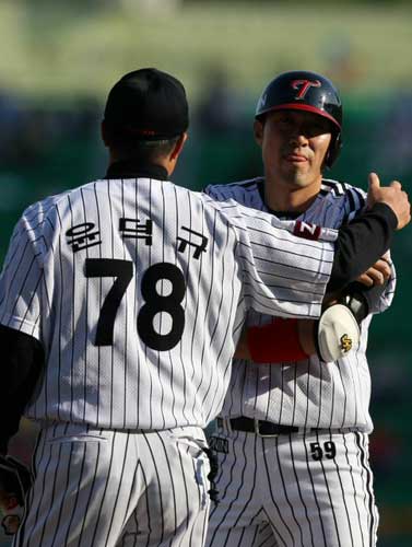  3일 서울 잠실야구장에서 열린 2009 프로야구 LG 트윈스-히어로즈 경기, LG 정성훈(오른쪽)이 1회말 1사 3루 상황에서 1타점 적시타를 친 후 윤덕규 코치의 축하를 받고 있다. 