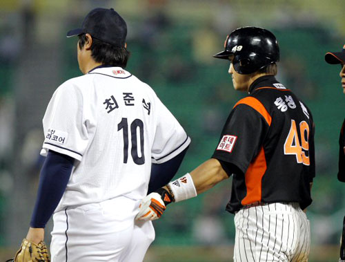 20일 서울 잠실야구장에서 열린 프로야구 두산과 롯데의 경기 7회초 1사 1루, 롯데 홍성흔이 안타를 때린 뒤 1루수 최준석의 유니폼을 잡아 당기고 있다. 