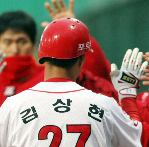  21일 광주무등경기장에서 벌어진 2009 프로야구 KIA 타이거즈와 LG 트윈스의 경기에서 1회말 1사 1, 2루 2타점 3루타를 쳐 3-3 동점을 만든 KIA 5번 김상현이 6번 김상훈의 희생 플라이로 홈인한 뒤 동료들과 하이파이브를 하고 있다. 