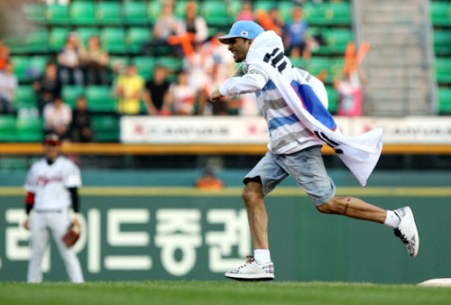 24일 오후 잠실야구장에서 열린 프로야구 LG 대 한화 경기. 7회초 태극기를 목에 건 한 외국인이 경기장에 난입해 경기가 잠시 중단되고 있다. 