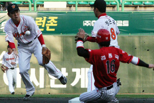  27일 인천 문학구장에서 열린 2009 프로야구 SK 와이번스-KIA 타이거즈 경기, SK 유격수 나주환(왼쪽)이 KIA 홍세완이 친 내야 땅볼을 잡아 2루에 송구하고 있다. 