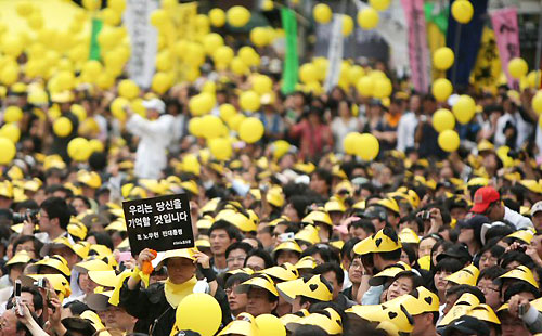 故노무현 전 대통령 국민장이 거행된 29일 서울광장에서 열린 노제에서 노란 풍선이 날리는 동안 한 시민이 '우리는 당신을 기억할것입니다' 검은 카드를 들어보이고 있다. 