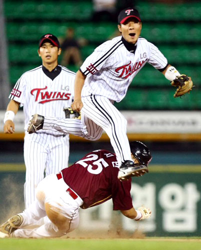 25일 서울 잠실야구장에서 열린 2009 프로야구 LG와 히어로즈의 경기에서 9회초 무사 히어로즈 타자 강정호의 내야땅볼을 LG 유격수 권용관이 직접 잡아 2루주자 송지만을 포스아웃 시킨 뒤 더블플레이를 위해 송구한 공을 바라보고 있다. 공은 타자를 아웃시킨 뒤 홈으로 중계 돼 3루주자 정수성도 아웃시켜 LG는 트리플 아웃 플레이로 9회초를 마쳤다. 