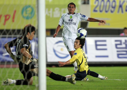 2일 경기 성남종합운동장에서 벌어진 2009프로축구 K-리그 성남일화-전북현대전에서 성남 골키퍼 정성룡(왼쪽)이 전북 에닝요(가운데)가 성남 수비수 장학영을 피해 슛팅한 공을 발로 걷어내고 있다. 