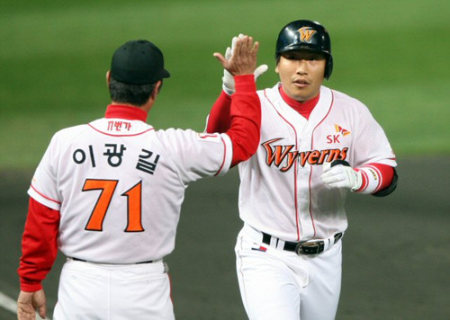 14일 오후 인천 문학구장에서 열린 프로야구 플레이오프 5차전 SK 와이번스-두산 베어스 경기. SK 박재홍이 1회말 선두타자로 나와 오른쪽 담장을 넘는 1점홈런을 때린 뒤 이광길 코치와 하이파이브를 하고 있다. 