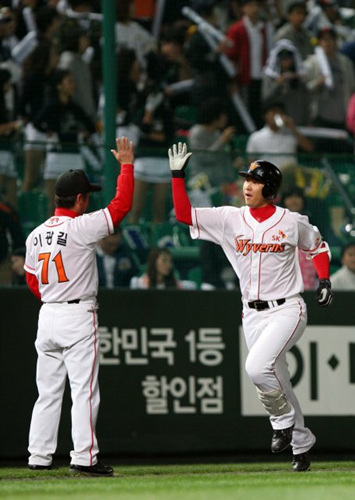 14일 인천 문학구장에서 열린 프로야구 플레이오프 5차전 SK와이번스-두산베어스 경기 1회말 2사에 SK 최정이 왼쪽담장을 넘기는 솔로홈런을 때린 뒤 3루를 돌며 이광길 코치와 하이파이브하고 있다. 