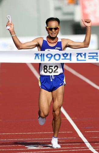 21일 대전 한밭종합운동장에서 열린 제90회 전국체육대회 남자 일반부 마라톤, ‘국민 마라토너’ 이봉주(충남 대표)가 자신의 은퇴 레이스에서 1위로 골인하며 두팔을 들고 기뻐하고 있다. 