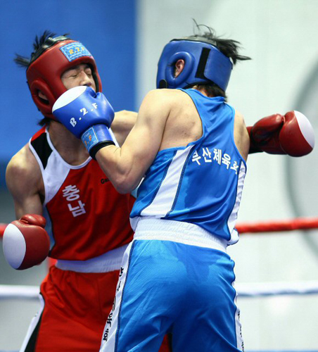 22일 대전 우송대학교 체육관에서 열린 제90회 전국체전 복싱 남자일반부 플라이급 (51kg) 이동원(충남.빨강)과 구승혁(부산.파랑)의 경기에서 선수들이 주먹을 주고받고 있다. 